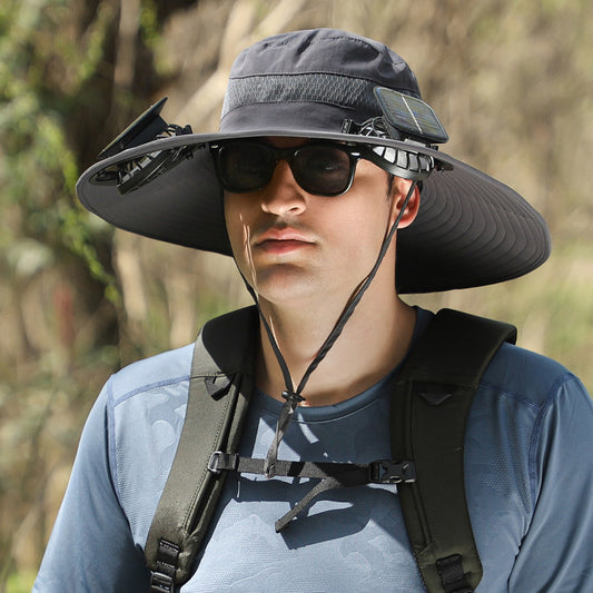 A person wearing the CJ'S Long Endurance Lithium Battery Fan Solar Charging Wind Sun Protection Hat along with sunglasses. They have a black backpack and are outdoors, surrounded by greenery.