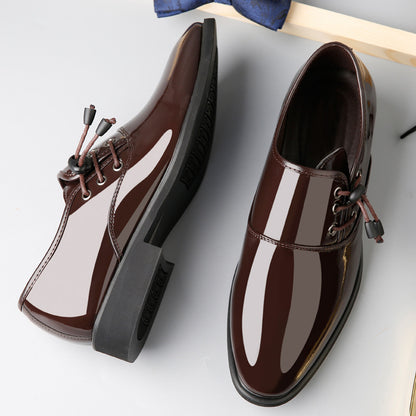 A pair of CJ's Men's Leather Lace-Up Business Casual Shoes, in a brown glossy finish with black soles and lace-up closure, featuring small black and maroon toggles. One shoe is lying on its side, displaying the tread of the sole, while the other stands upright. The background is a light gray surface.