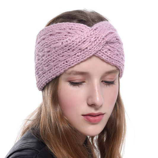 A woman with long, wavy hair is wearing the CJ'S Women's Thick Knit Wool Headband featuring a diagonal cross design. She has her eyes closed and is dressed in a black top against a solid white background.