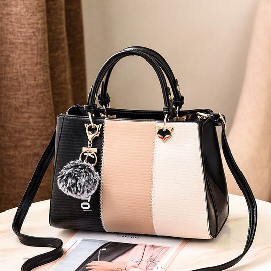 Stylish two-tone crossbody handbag with charm accents and a spacious interior