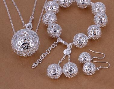 The Elegant Silver Filigree Ball Jewellery Set from CJ'S includes a necklace with a large spherical pendant, a bracelet adorned with multiple spherical beads, and a pair of elegant drop earrings. The sophisticated design features intricate silver-tone filigree, beautifully displayed on a flat, brown background.