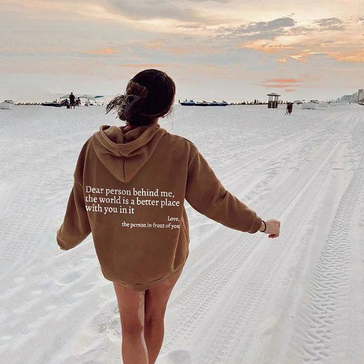 Woman wearing khaki hoodie with uplifting message