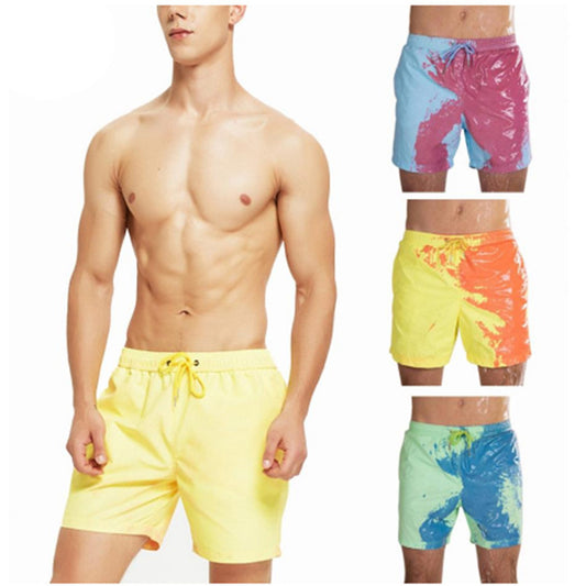 A model displays yellow Magical Change Color Beach Shorts, made from polyester fiber, with three more pairs shown to the right in a range of colors: blue with pink, yellow with orange, and light green with blue.