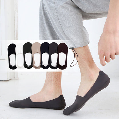 A person wearing Zendrop's Men's Ice Silk Silicone Anti-off Invisible Pure Cotton Sweat Absorbing Boat Socks in gray showcases seven pairs of sweat-absorbent socks beside their feet, available in black, white, gray, beige, brown, and two multi-colored designs. The person is dressed in light gray pants, indoors.