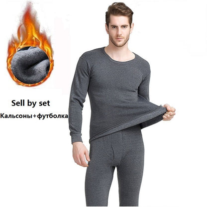 A person models the Men's Warm Thermal Underwear Set in gray, consisting of a shirt and pants, designed for softness, breathability, and comfort. The background features fabric imagery with a flame graphic to emphasize the heat-retaining properties. To the left is Russian text reading "Calсonы + футболка" (which translates to "Long Johns + T-shirt").