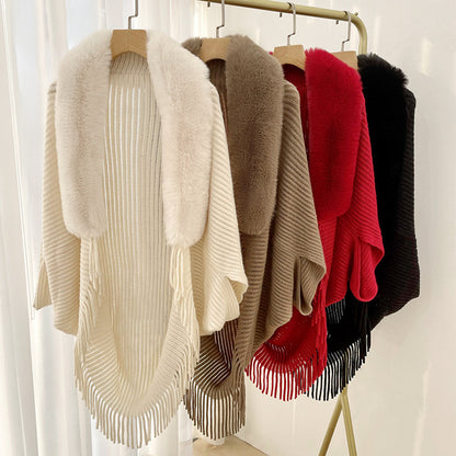 Four CJ'S Scarf Women Solid Color Cashmere shawls are hanging on a rack, each crafted from knitted cashmere material and featuring a fur collar with fringe along the bottom edge. These solid color shawls come in cream, taupe, red, and black, arranged from left to right against a backdrop of white curtains.