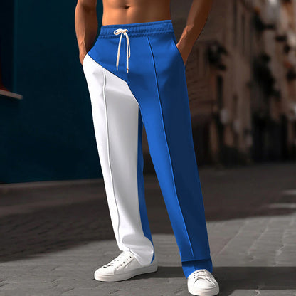 Amidst the dimly lit urban street, a person showcases the Straight Color Matching Casual All-matching Pants, featuring one blue leg and the other white. Complementing this bold design, they sport crisp white sneakers, effortlessly merging fashion with urban flair.