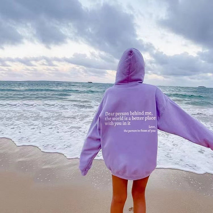 Woman in lavender hoodie with inspirational quote on the beach