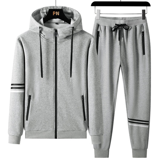 The Men's Casual Sports Pure Cotton Hooded Sweater Trousers Two-piece Set by CJ'S, ideal for sports, is displayed on hangers in a stylish gray color with black drawstrings. The hooded sweatshirt features a full front zipper, two zippered pockets, and black stripe designs on the sleeves. The matching jogger pants include an elastic waistband with drawstrings and black zippered pockets.