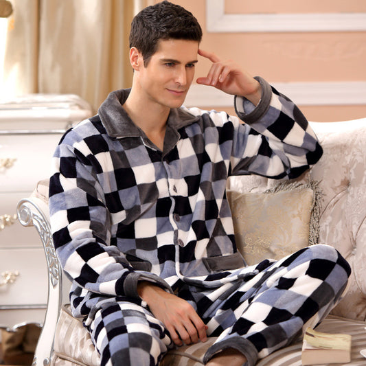 A person lounges on a couch in the ultra-soft Men's Mink Flannel Loungewear Set - Cosy Home Wear, featuring a cozy black and white checkered design. The room is adorned with soft, neutral decor, including a white dresser and cream-colored walls that enhance the serene atmosphere.